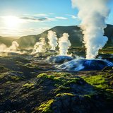 Das Bild zeigt eine grüne Landschaft mit heißen Quellen und erinnert damit an Erdwärme.